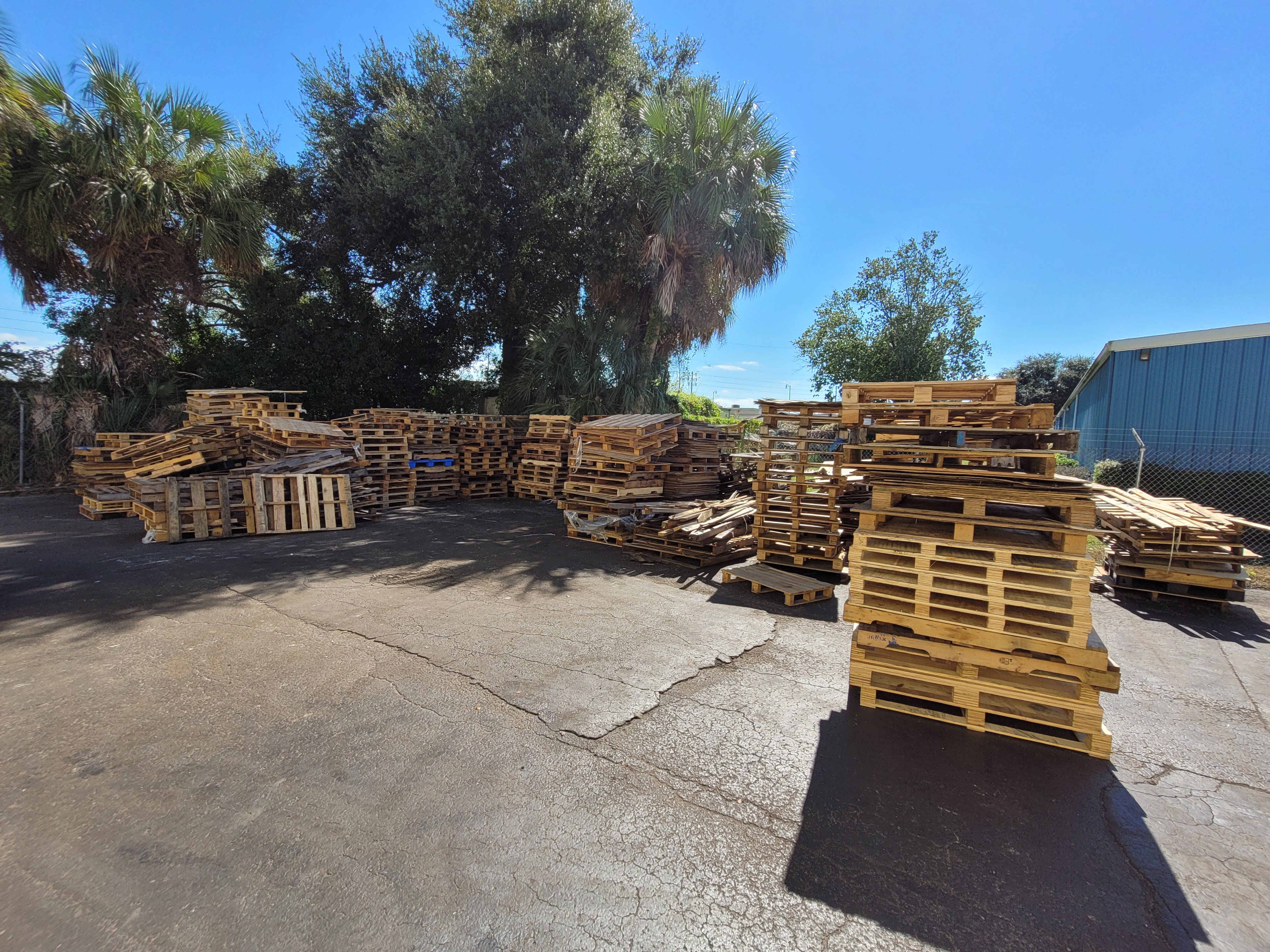 HF Pallets drop trailer stationed at warehouse loading dock for pallet scrap recycling